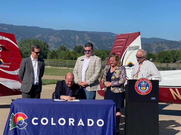 Colorado Governor Pollis signing bill at airport